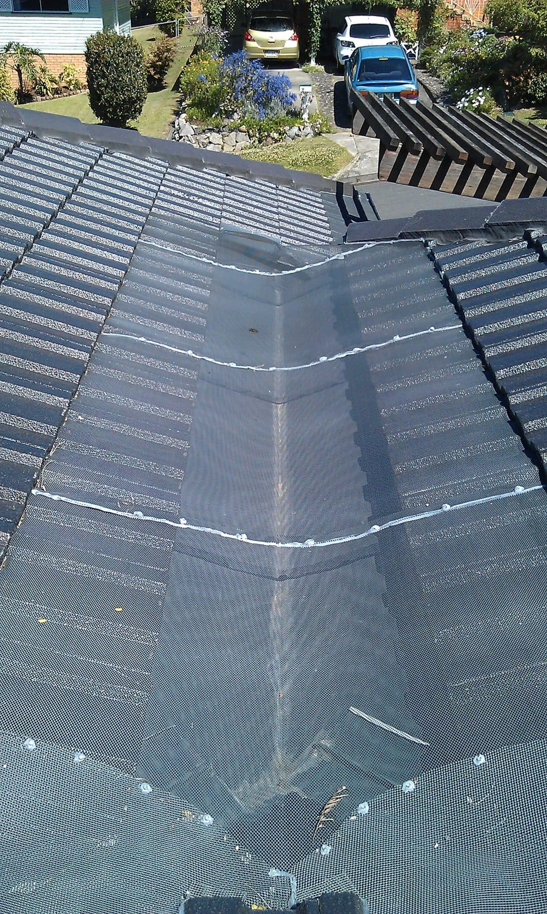 Gutter guard protecting the valley of a charcoal metal roof